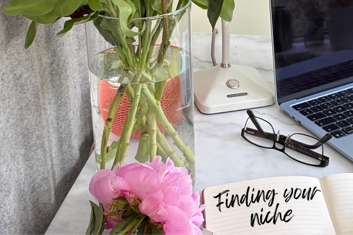 Notebook on marble desk with peony and vase